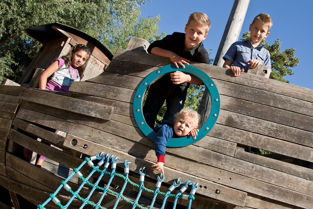 Eine Gruppe Kinder entert das Piratenschiff auf dem Abenteuerspielplatz.